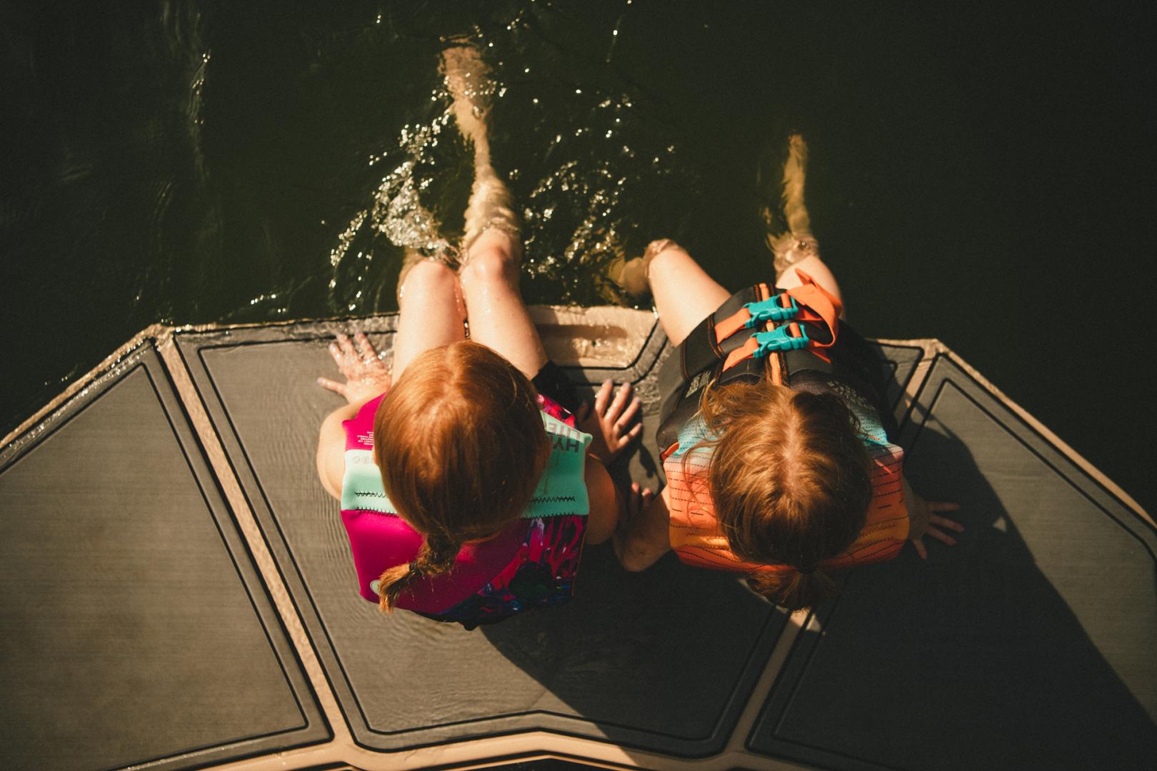 Kids sitting on the back of a boat 